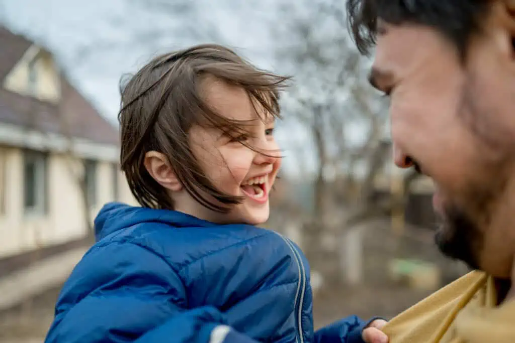A child laughs with their parent after enjoying one of their favorite family bonding activities.